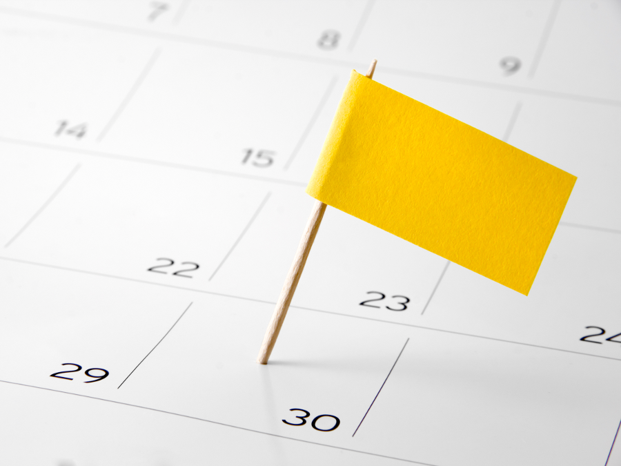 Ein gelbes Markierungsfähnchen steckt in einem Kalendereintrag.