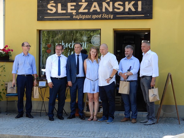 Minister Vogelsänger mit Vizemarschall Gwóźdź sowie weitere Teilnehmer des Arbeitsbesuchs vor dem Laden für regionales Kunsthandwerk in Sobótka
