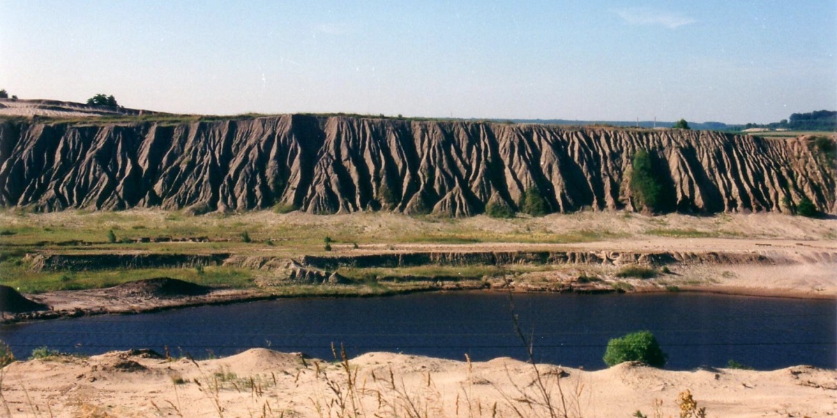 Bild: Blick auf einen Tagebaurestsee - im Hintergrund sind die aufgeschütteten Sanddünen vom Tagebau zu sehen.