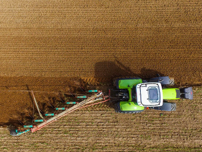 Ein Landwirt pflügt an einem Acker (Luftaufnahme mit einer Drohne).