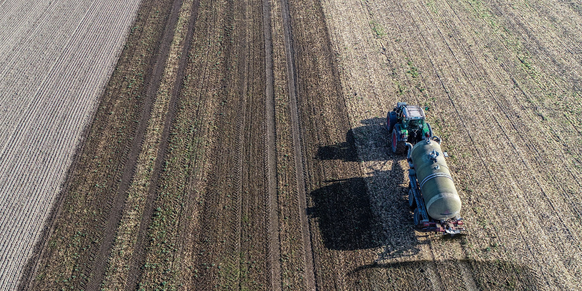 Bild: Auf einem Feld werden Gärreste aus einer Biogasanlage ausgebracht (Luftaufnahme mit einer Drohne).
