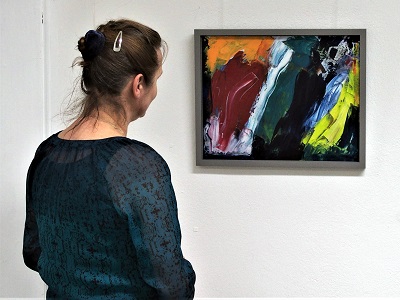 Eine Besucherin betrachtet eine Malerei.